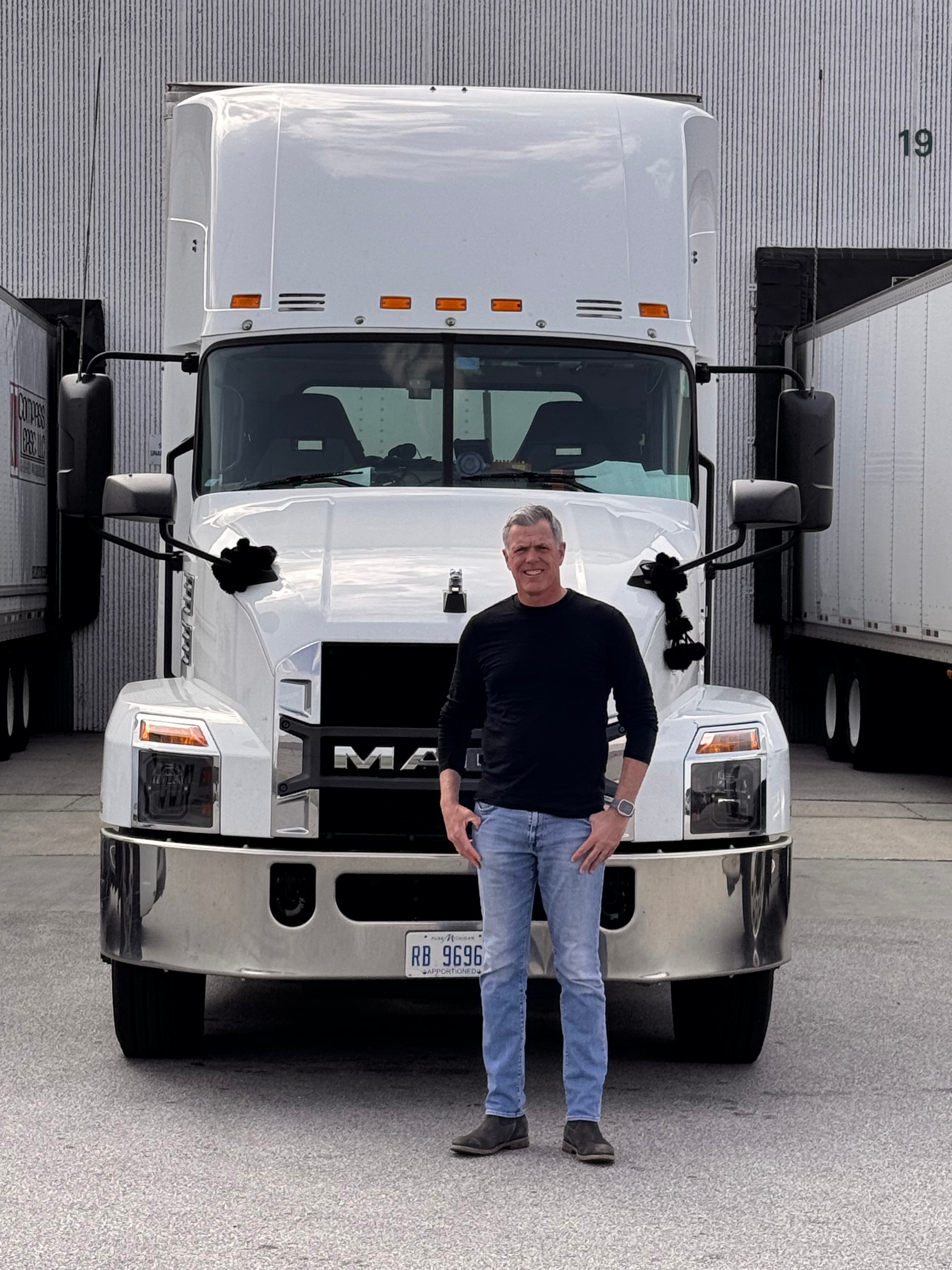 Kayne Grau standing in front of a Mack truck